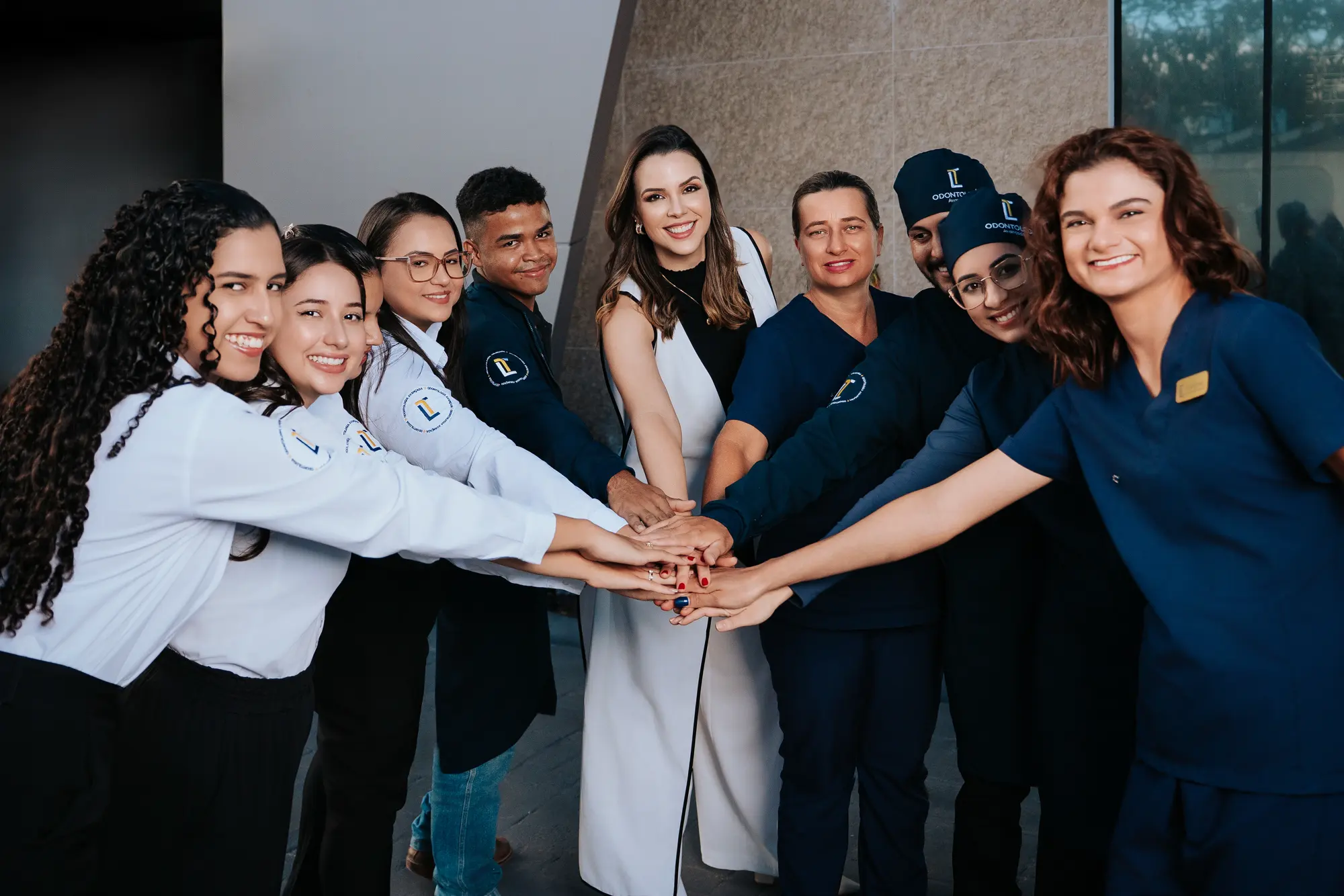 Equipe da LT Odontologia com as mãos unidas ao centro